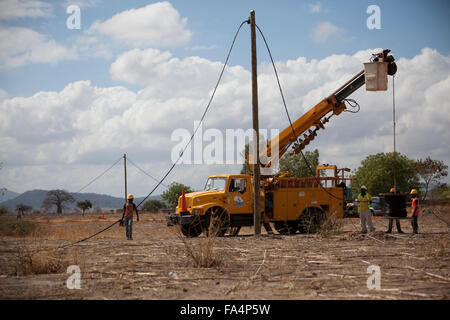 Chaîne de travailleurs nouveaux câbles d'alimentation dans un village rural près de Dodoma, Tanzanie, Afrique de l'Est. Banque D'Images