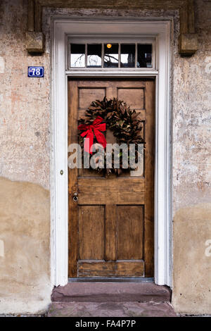 Porte à un accueil traditionnel le long de la rue de l'église décorée d'une couronne de Noël pour la période des fêtes dans le quartier historique de Charleston, SC. Banque D'Images