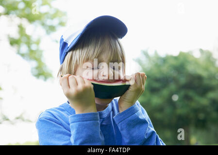 Garçon profitant tranche de pastèque au picnic, Munich, Bavière, Allemagne Banque D'Images