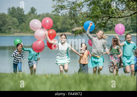 Les enfants courent en parc avec des ballons, Munich, Bavière, Allemagne Banque D'Images