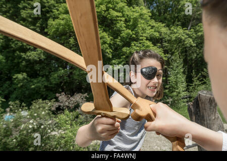 Deux filles prétendant en pirates combats d'épées en terrain d'aventure, Bavière, Allemagne Banque D'Images