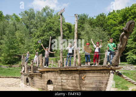 Groupe d'enfants jouant sur un bateau pirate en terrain d'aventure, Bavière, Allemagne Banque D'Images