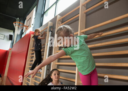 Trois jeunes filles exerçant sur le mur de bars dans grande salle de sport, Munich, Bavière, Allemagne Banque D'Images