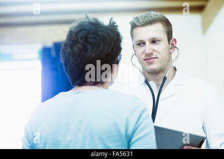 Parler aux jeunes patients matures médecin dans un hôpital, Freiburg im Breisgau, Bade-Wurtemberg, Allemagne Banque D'Images