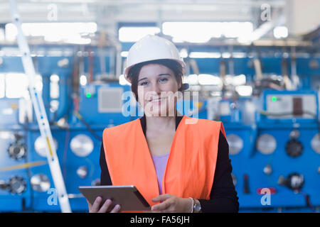 Ingénieur femelle à l'aide d'une tablette numérique dans une installation industrielle, Freiburg im Breisgau, Bade-Wurtemberg, Allemagne Banque D'Images