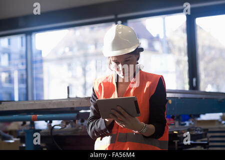 Ingénieur femelle à l'aide d'une tablette numérique dans une installation industrielle, Freiburg im Breisgau, Bade-Wurtemberg, Allemagne Banque D'Images