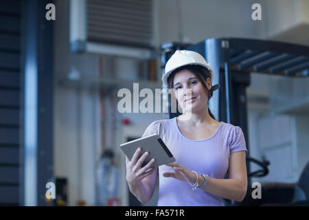 Ingénieur femelle à l'aide d'une tablette numérique dans une installation industrielle, Freiburg im Breisgau, Bade-Wurtemberg, Allemagne Banque D'Images