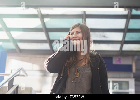 Young Woman talking on mobile phone and smiling, Freiburg im Breisgau, Bade-Wurtemberg, Allemagne Banque D'Images