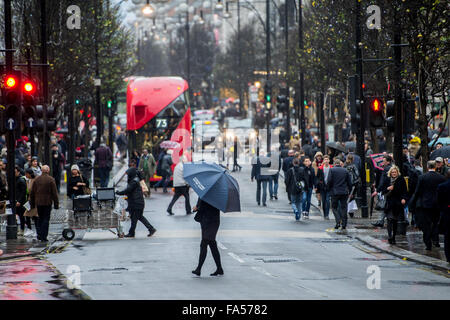 Londres, Royaume-Uni. 21 Décembre, 2015. Des milliers d'acheteurs de Noël brave la pluie et lutte avec des parasols sur Oxford Street de Londres. Credit : Pete Maclaine/Alamy Live News Banque D'Images