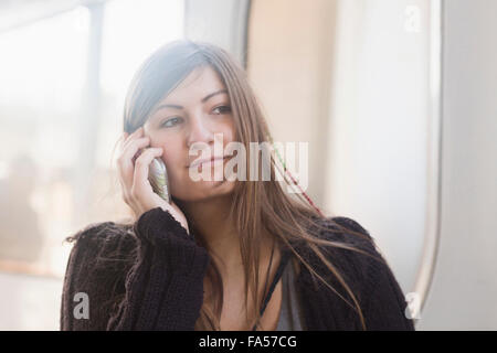 Young Woman talking on mobile phone en face de la gare, Freiburg im Breisgau, Bade-Wurtemberg, Allemagne Banque D'Images