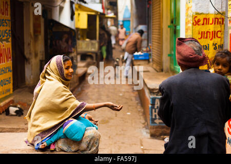 Pauvre femme assis dans dirty doctor holding baby mendier de l'argent d'un passant Banque D'Images