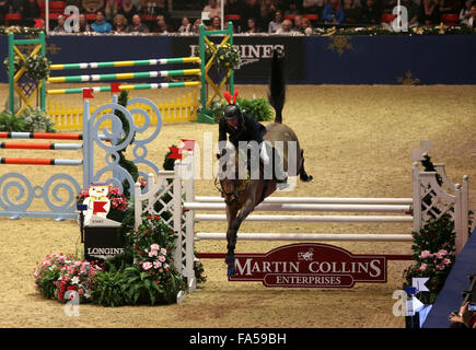 Londres, Royaume-Uni. Dec 21, 2015. John Whitaker de Grande-Bretagne est en concurrence au cours de la compétition de saut de relais paire le London International Horse Show 2015 à l'Olympia, Londres, Grande-Bretagne le 21 décembre 2015. John Whitaker et Robert Whitaker de Grande-Bretagne le troisième rang. Credit : Han Yan/Xinhua/Alamy Live News Banque D'Images