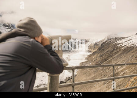 Man looking at view avec télescope, Pasterze glacier, Parc National Hohe Tauern, Carinthie, Autriche Banque D'Images