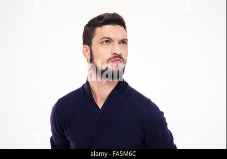 Insatisfait de froncer beau jeune homme avec barbe en sweetshirt looking away over white background Banque D'Images