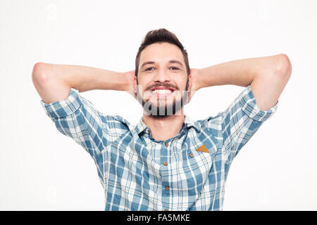 Heureux insouciant jeune homme barbu en chemise à carreaux avec les mains derrière la tête sur fond blanc Banque D'Images