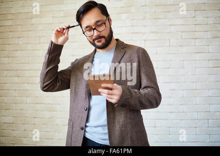 Asian businessman avec le bloc-notes à la recherche de nouvelles idées Banque D'Images