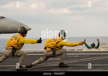 Les marins de la Marine américaine donnent le signal pour un avion de chasse à bord du porte-avions de classe Nimitz USS Dwight D. Eisenhower le 10 décembre 2015, opérant dans l'océan Atlantique. Banque D'Images