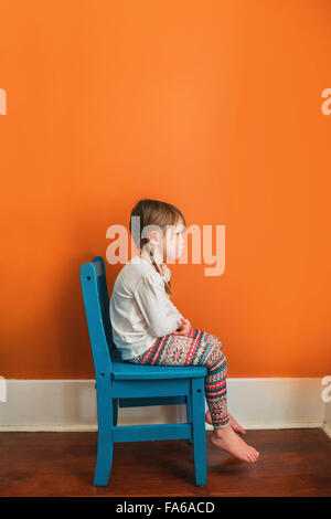 Fille assise sur une chaise tacaud Banque D'Images