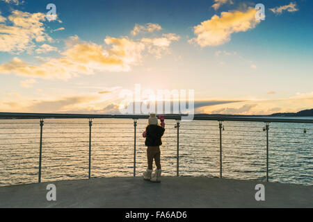 Girl standing on bridge au coucher du soleil à la Banque D'Images