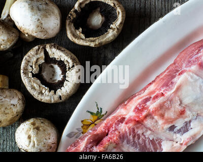 Côtes de porc cru et champignons frais Banque D'Images