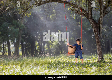 Girl sitting on swing avec son chien Banque D'Images