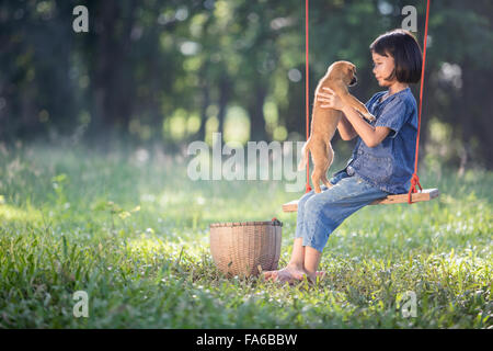 Fille sur rope swing avec son chien Banque D'Images