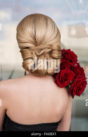 Vue arrière d'une femme tenant un bouquet de roses rouges Banque D'Images