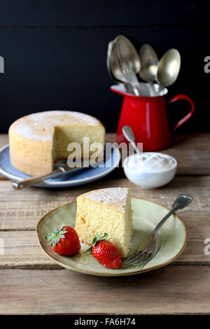 Tranche de gâteau à la crème et des fraises fraîches sur une plaque Banque D'Images