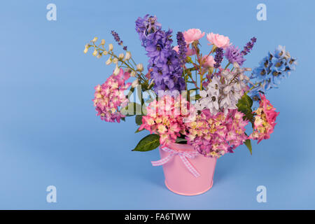 Bouquet de fleurs mixtes en vase colorés sur fond coloré Banque D'Images