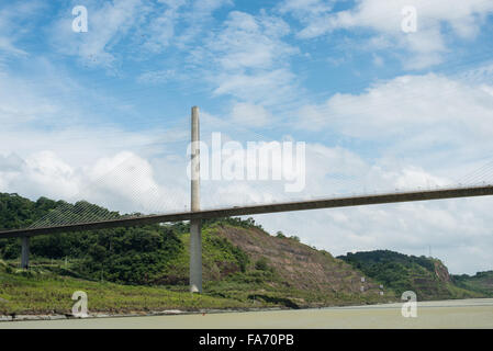 Pont Centennial Canal de Panama Ciudad de Panama Panama | CANAL DE PANAMA, Panama — Le pont Centennial enjambe la coupe Gaillard du Canal de Panama près des écluses de Pedro Miguel, portant l'autoroute panaméricaine au-dessus de la voie d'eau. Achevé en 2004 pour marquer le centième anniversaire de l'indépendance panaméenne, l'ouvrage à câbles tendus s'élève à environ 262 pieds (80 m) au-dessus du canal, une hauteur de gabarit conçue pour les navires Panamax. Sa travée principale de 420 mètres, soutenue par un seul pilier en béton de 184 mètres, était à son ouverture la plus longue travée à câbles tendus en béton des Amériques. Banque D'Images