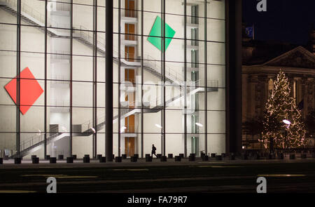 Berlin, Allemagne. Dec 23, 2015. L'esquisse d'un homme marchant passé la Paul-Loebe-Haus (lit. Paul Loebe House), partie du Bundestag allemand, le parlement, avec l'arbre de Noël illuminé du Reichstag (parlement (R), représenté à l'arrière-plan, à Berlin, Allemagne, 23 décembre 2015. Photo : Lukas SCHULZE/dpa/Alamy Live News Banque D'Images