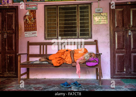 Vieux sadhu baba (saint homme) dormir sur un banc Banque D'Images