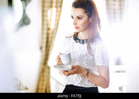 Pretty young woman drinking coffee Banque D'Images