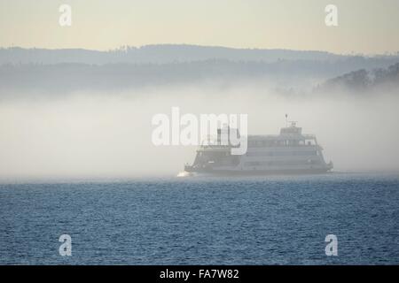 Un car-ferry sur le lac de Constance têtes à travers un mur de brouillard vers Meersburg, à Constance, Allemagne, 23 décembre 2015. PHOTO : FELIX KAESTLE/DPA Banque D'Images