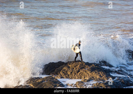 Aberystwyth, Ceredigion, West Wales, UK. 23 Décembre, 2015. Avant d'Eva tempête devrait frapper la côte surfers profiter de l'insolite au temps doux avec la poursuite de grosses vagues sur la côte ouest de Borth juste au nord d''Aberystwyth. Le surfeur brouille entre les rochers et les vagues esquives afin de sauver la natation. Credit : Trebuchet Photography/Alamy Live News Banque D'Images