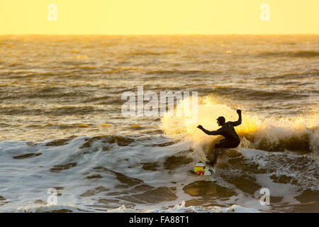 Aberystwyth, Ceredigion, West Wales, UK. 23 Décembre, 2015. Avant d'Eva tempête devrait frapper la côte surfers profiter de l'insolite au temps doux avec la poursuite de grosses vagues sur la côte ouest de Borth juste au nord d'Aberystwyth au coucher du soleil. Credit : Trebuchet Photography/Alamy Live News Banque D'Images