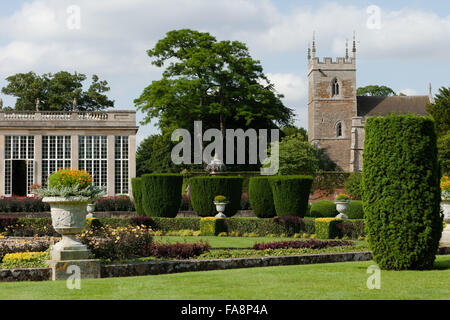 L'Orangerie et le jardin italien en juillet à Belton House, Lincolnshire. L'église paroissiale de SS Pierre et Paul (pas la propriété de la National Trust) est sur la droite. Banque D'Images