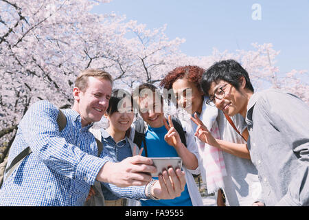Multi-ethnic group of friends enjoying cerisiers en fleur à Tokyo Banque D'Images