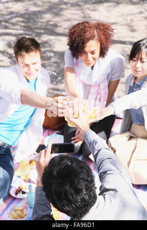 Multi-ethnic group of friends enjoying cerisiers en fleur à Tokyo Banque D'Images