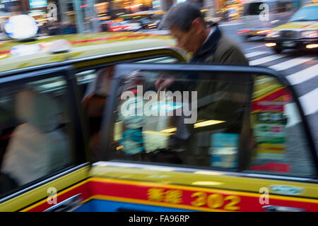 Tokyo, Japon - Dec 10, 2015 : Un homme d'affaires japonais d'entrer dans un taxi dans la rue animée du quartier de Ginza, à Tokyo. Banque D'Images