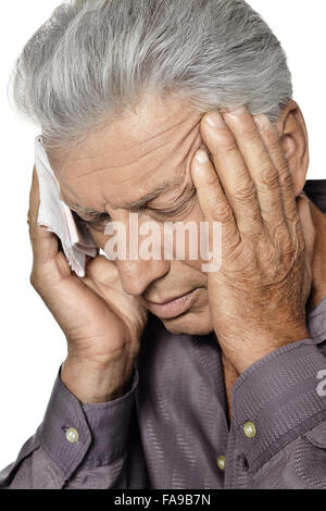 Un homme âgé souffrant d'un mal de tête Banque D'Images