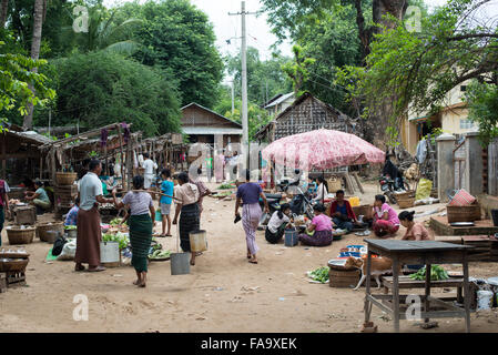 Myinkaba, Myanmar — des vendeurs locaux exposent des produits frais et des marchandises au marché du matin dans le village de Myinkaba, près de Bagan, Myanmar. Des fruits colorés, des légumes et des aliments traditionnels bordent des stands de fortune le long de la rue. Banque D'Images