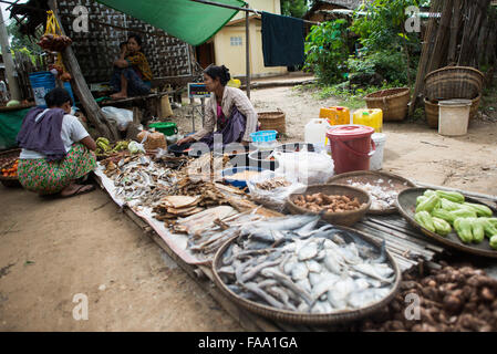 Myinkaba, Myanmar — des vendeurs locaux exposent des produits frais et des marchandises au marché du matin dans le village de Myinkaba, près de Bagan, Myanmar. Des fruits colorés, des légumes et des aliments traditionnels bordent des stands de fortune le long de la rue. Banque D'Images