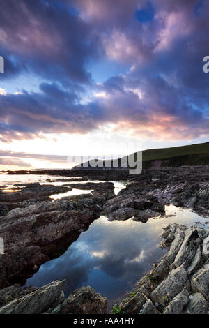 Coucher de soleil sur la plage de rochers à Portwrinkle Crafthole Cornwall UK Banque D'Images