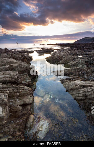 Coucher de soleil sur la plage de rochers à Portwrinkle Crafthole Cornwall UK Banque D'Images
