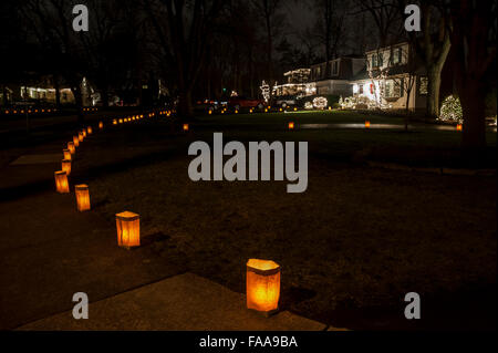 Chicago, USA. 24 décembre 2015. L'avant des maisons jardins dans le village de Clarendon Hills sont décorées avec "Luminaria", allumé des bougies dans des sacs en papier brun. Célèbre son 50e anniversaire, la tradition annuelle exige que les résidents locaux pour allumer les bougies chaque veille de Noël et soulève des fonds pour des organismes d'aide à l'enfance, avec plus de 30 000 bougies allumées. Crédit : Stephen Chung / Alamy Live News Banque D'Images