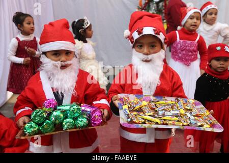 Katmandou, Népal. Le 24 décembre, 2015. Deux enfants népalais habillé en père Noël tenir cadeaux pendant une fête la veille de Noël à Katmandou, Népal, 24 décembre 2015. Credit : Sunil Sharma/Xinhua/Alamy Live News Banque D'Images