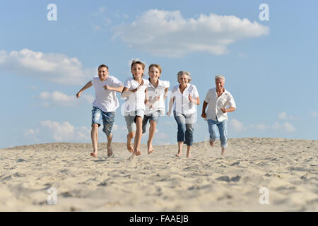 Les garçons avec les grands-parents sur le sable Banque D'Images