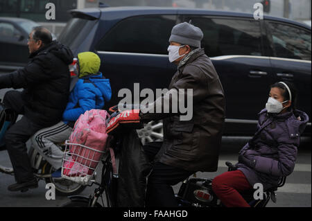 Les gens portent des masques qu'un épais brouillard de pollution de l'air des enveloppes Beijing, Chine. 25-Déc-2015 Banque D'Images