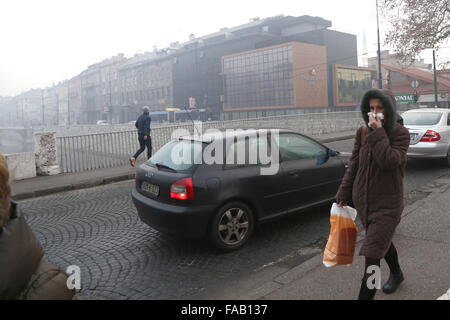 Sarajevo, Bosnie-Herzégovine. Dec 25, 2015. Les gens marcher dans la rue dans la brume sèche à Sarajevo, Bosnie-Herzégovine, le 25 décembre, 2015. En raison de la pollution atmosphérique, toutes les écoles primaires et secondaires du canton de Sarajevo sont fermées le 24 décembre et le 25 décembre. Credit : Haris Memija/Xinhua/Alamy Live News Banque D'Images